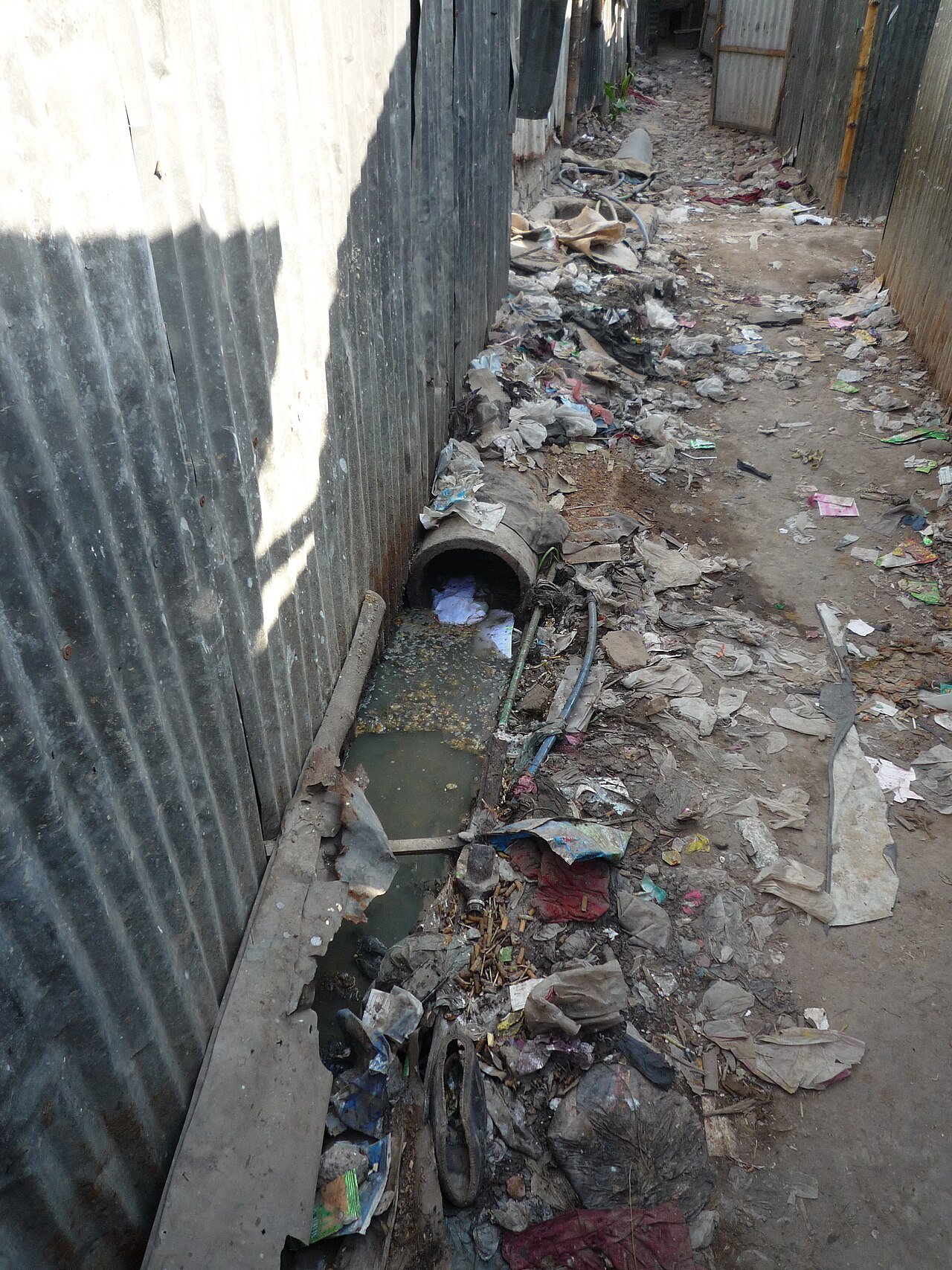 Open sewer trench and refuse in a narrow alley